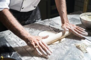 laminating dough on a counter.