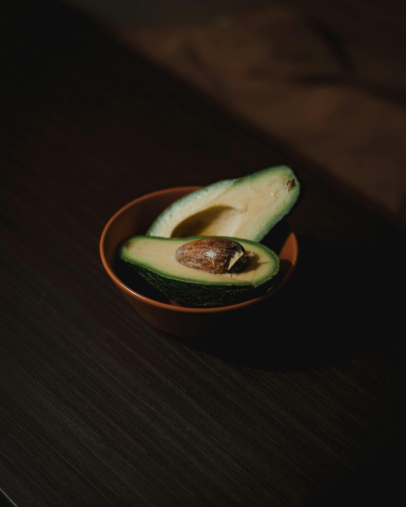 A Ripe Avocado Cut in Half in a Bowl