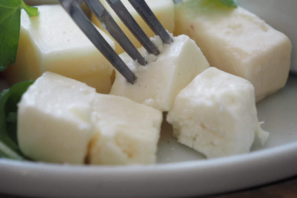 Feta cheese Cubes with a Fork Digging in