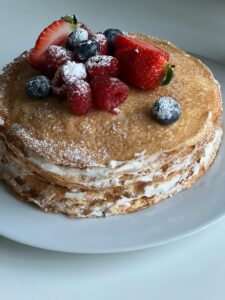 French toast souffle with cardamom cream garnished with berries