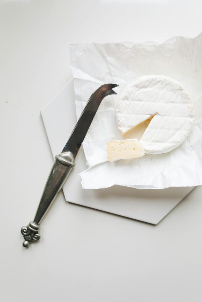 A Block of Goat Cheese with a knife and a white background