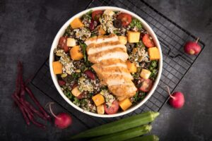 kale and Quinoa salad with a sliced roasted chicken breast on top