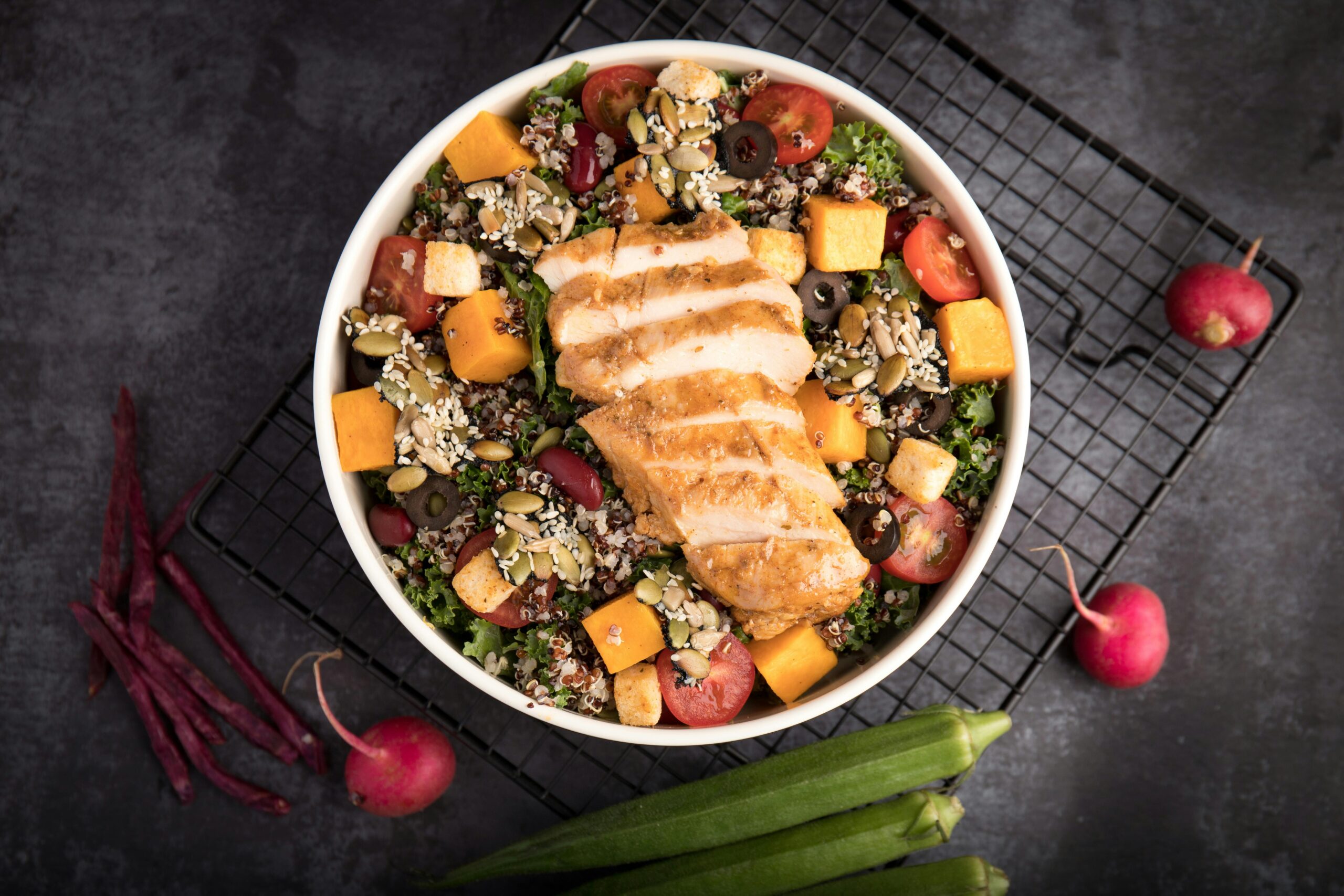 kale and Quinoa salad with a sliced roasted chicken breast on top