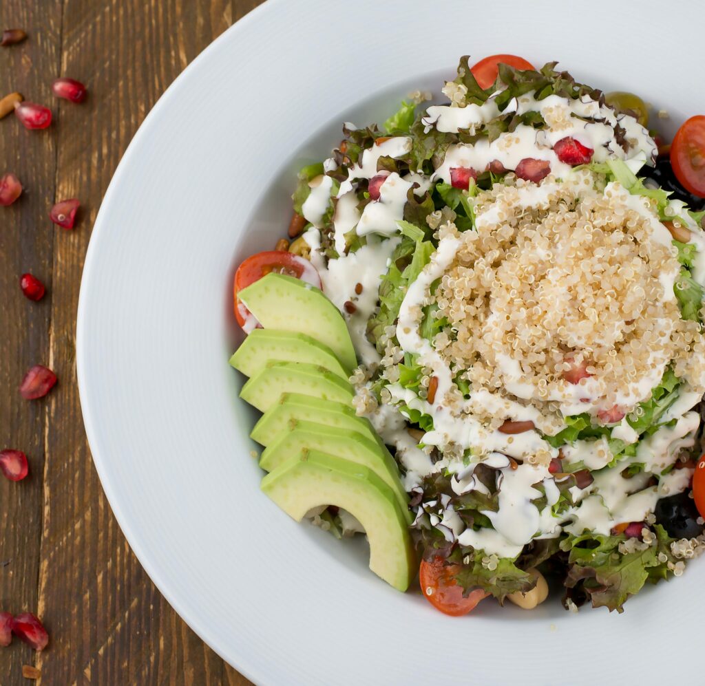 quinoa and kale salad garnished with almod and sliced avocado