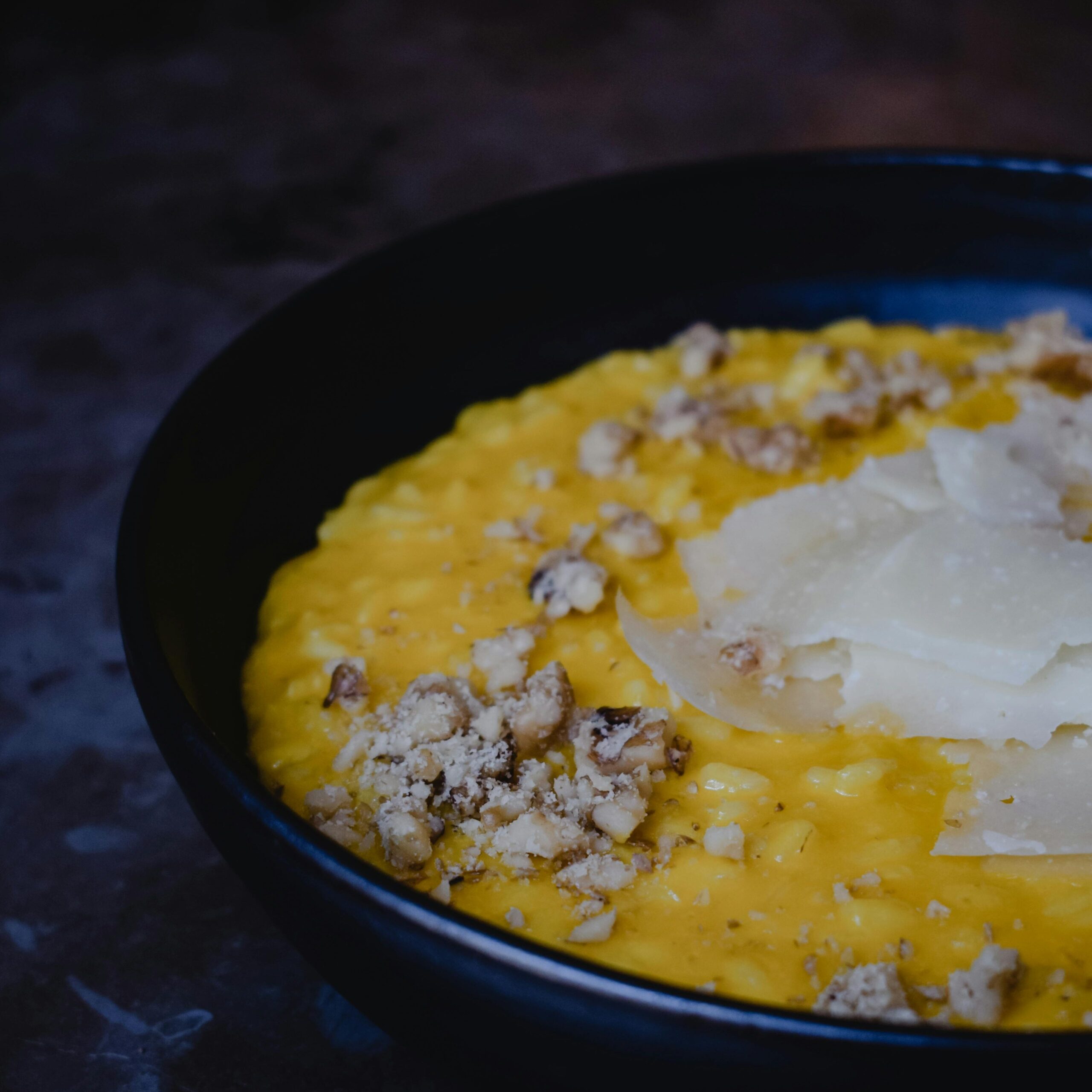 Saffron Resotto served in a black high edges plate