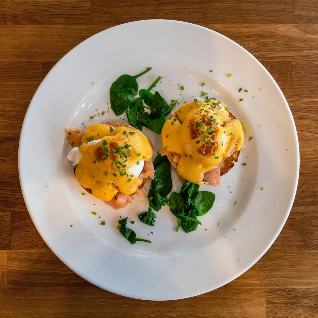 Ultimate Smoked Salmon Benedict with Hollandaise Foam served in a plate and garnished with herbs