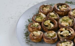 Stuffed Portobello Mushrooms garnished with herbs and served in a white plate