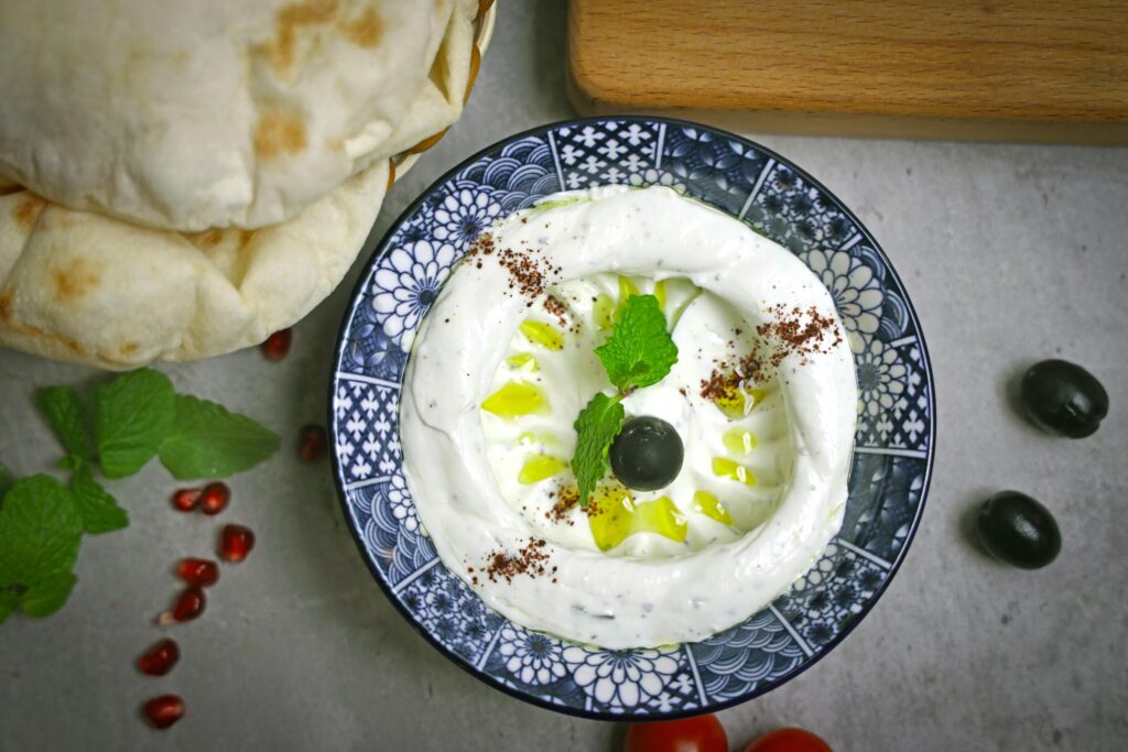 Tahini in a Plate Garnished with herbs and Olives