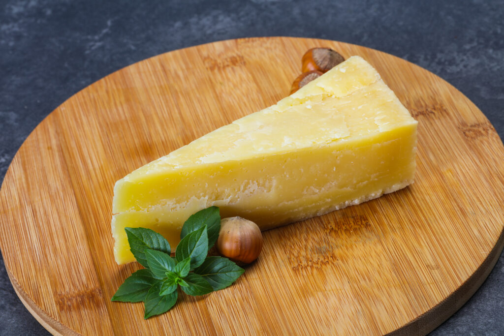 A Block of Parmesan Cheese and nuts Served On a Wooden Block