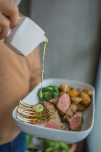 Herb-crusted rack of lamb served with mint chimichurri and roasted root vegetables