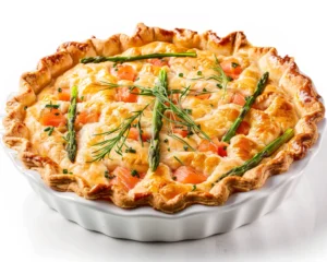 A golden-brown goat cheese tart topped with fresh asparagus spears and sprigs of dill, served in a white ceramic tart dish.