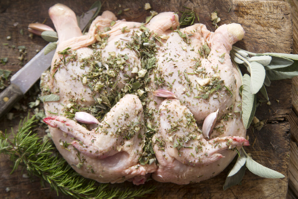 Preparation of a whole chicken with Mediterranean herbs