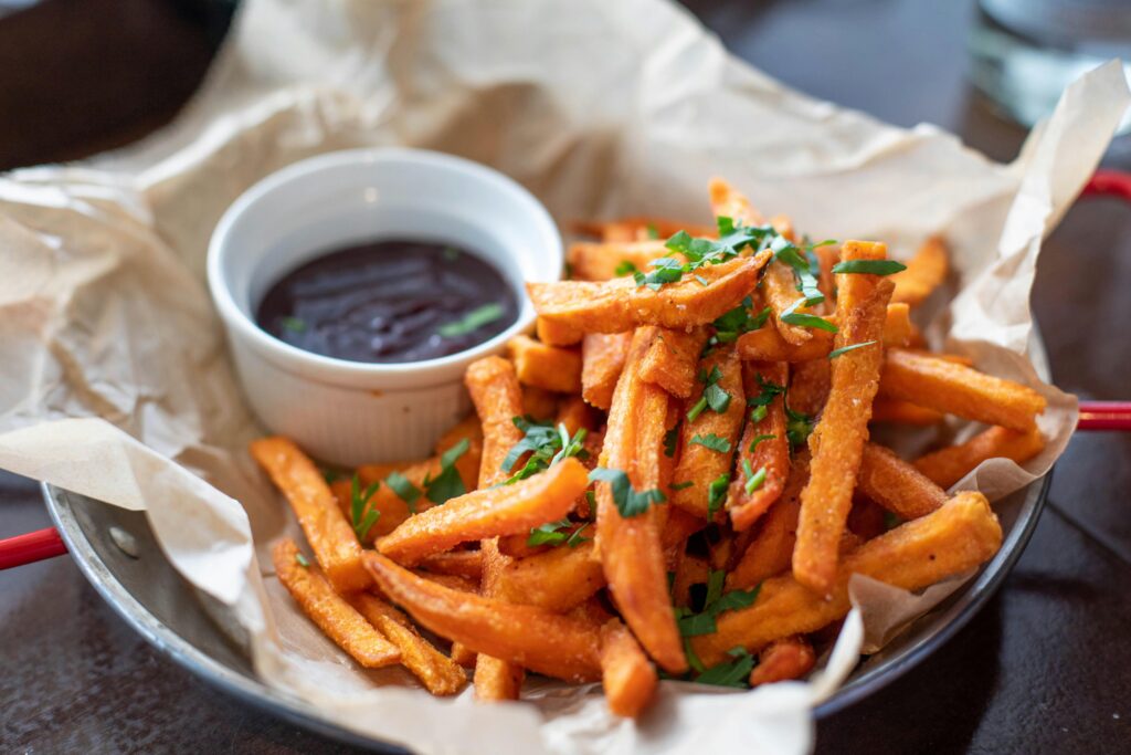 Crispy sweet potatoes in a plate with sauce