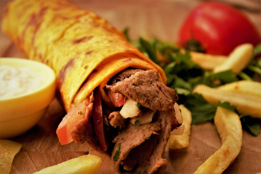 Lamb Gyro Wraps with a tomato, hern and frech fries 