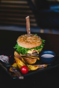 lamb burgers with mint yogurt sauce along with french fries in a black plate