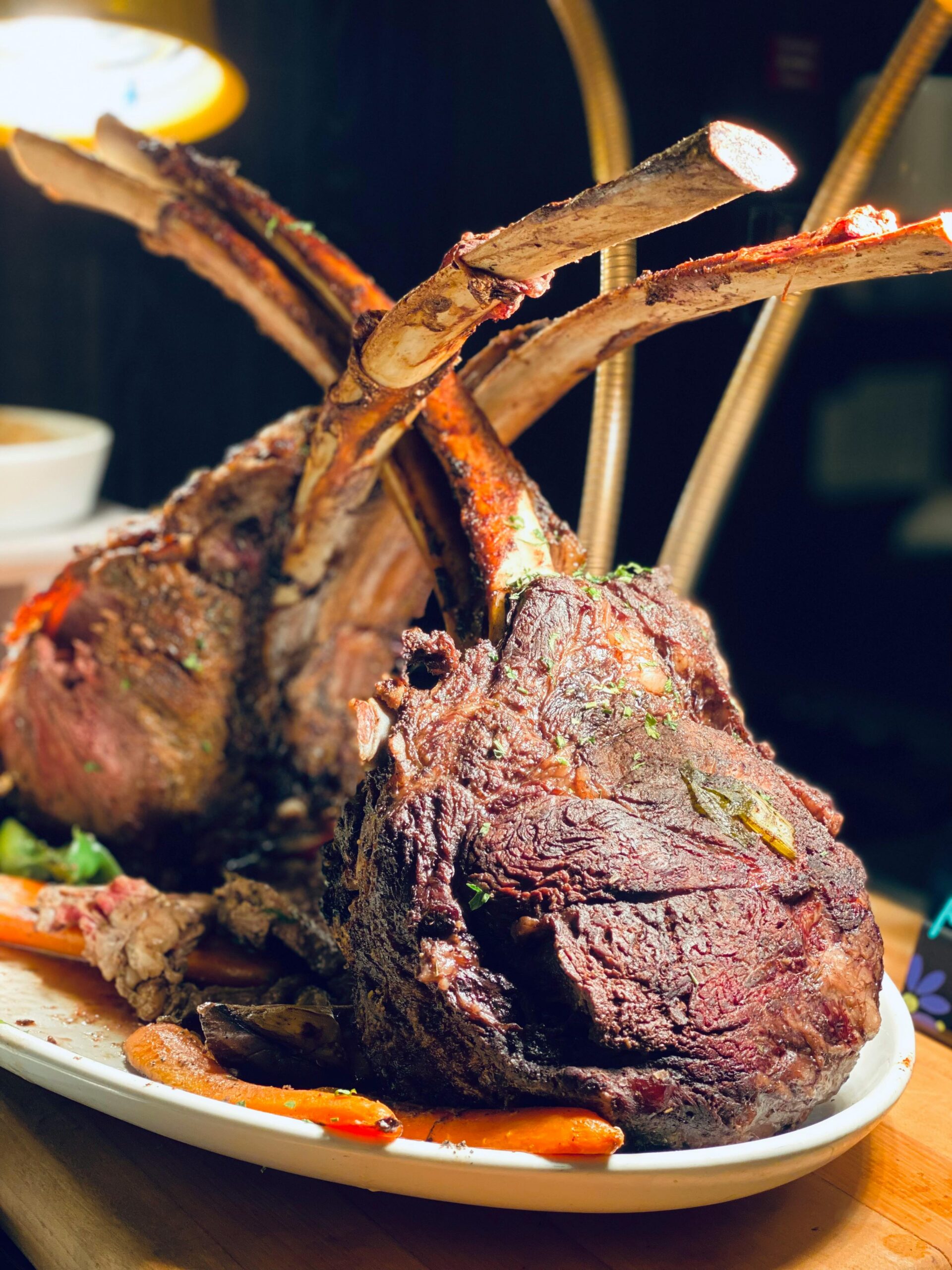 serad lamb chops in a white plate with vegetables