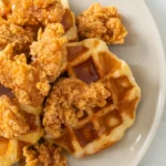 Golden fried chicken tenders served on fluffy waffles drizzled with maple syrup.