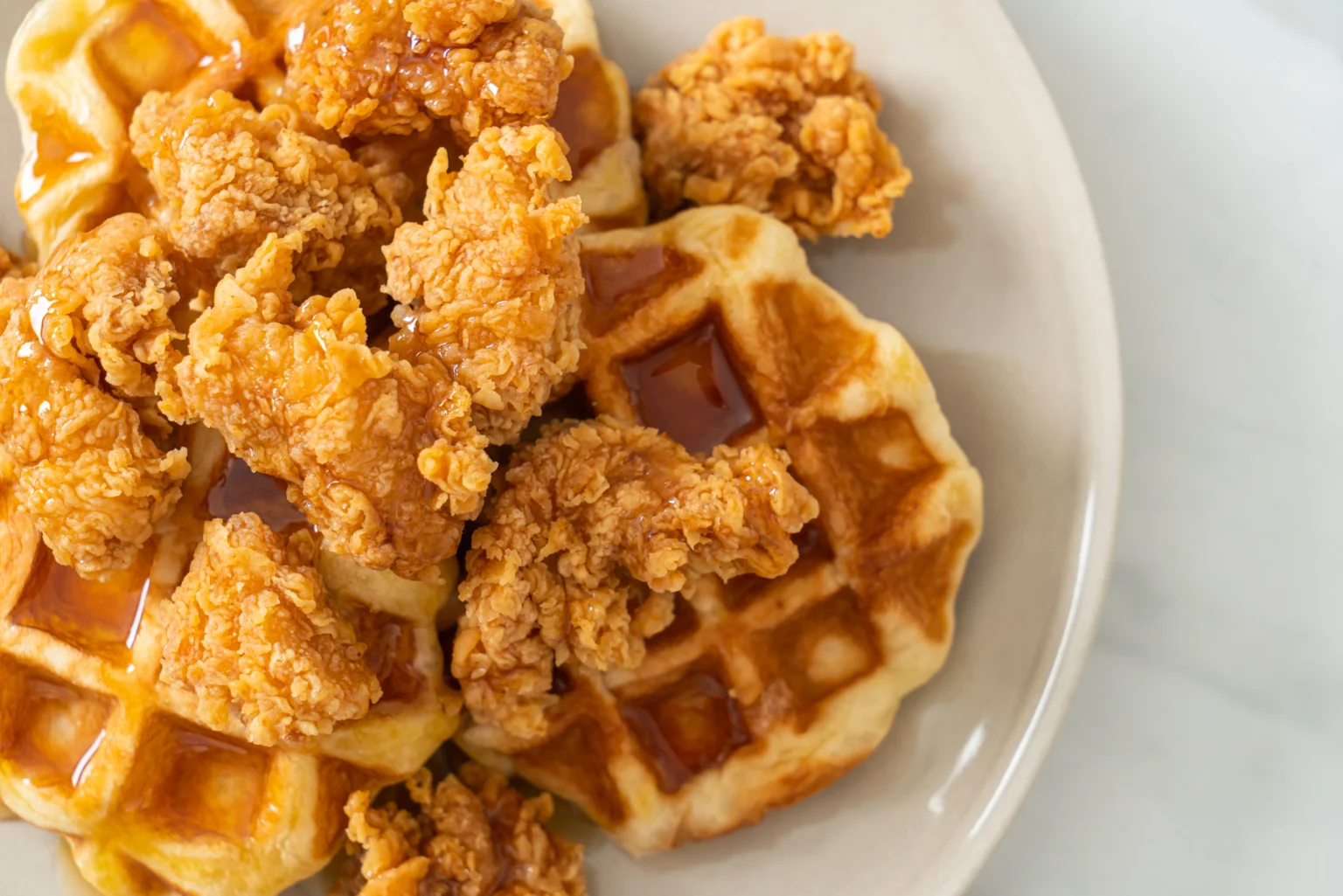 Golden fried chicken tenders served on fluffy waffles drizzled with maple syrup.