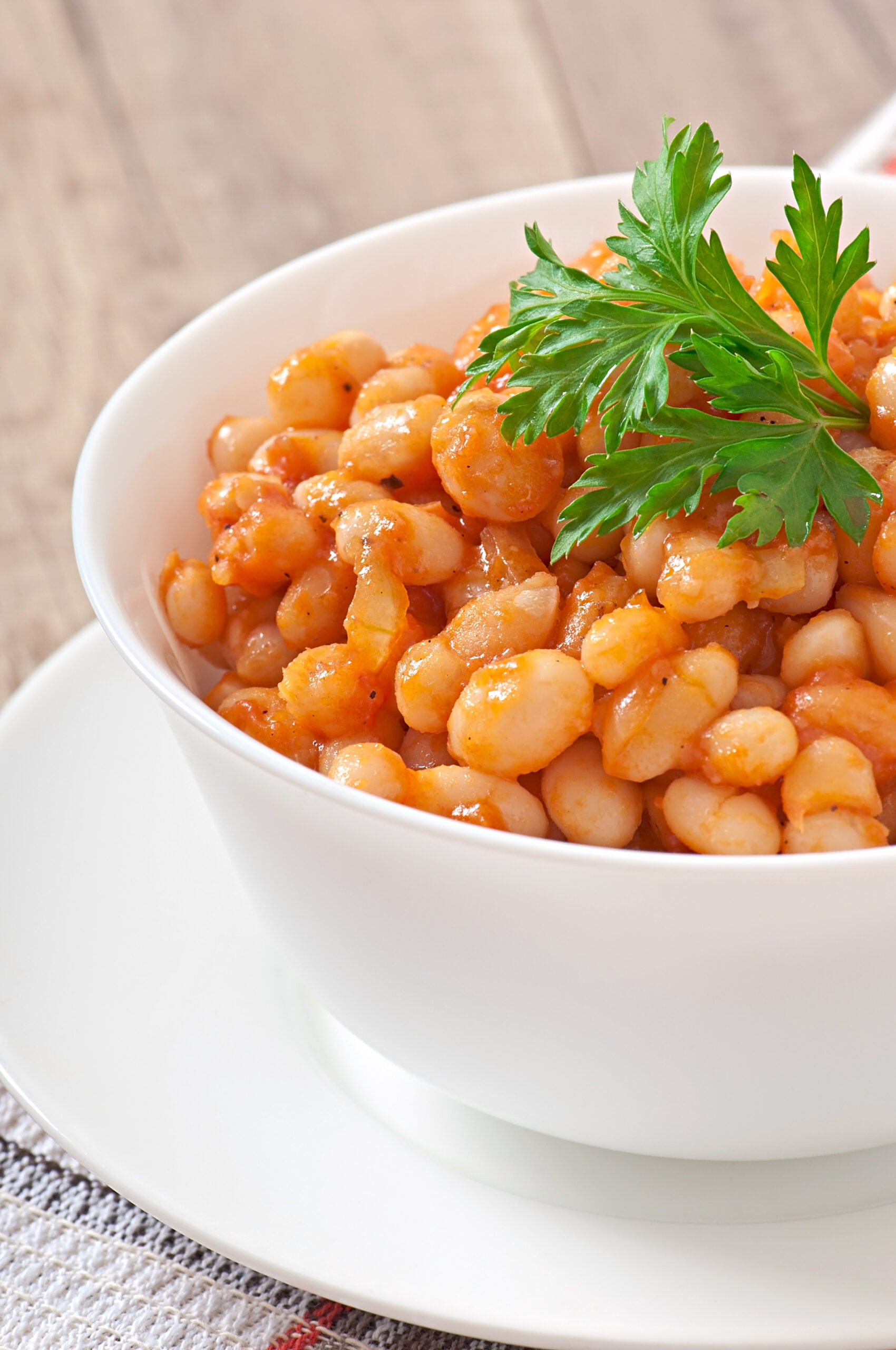 stew bean in a white bowl garnished with green herbs