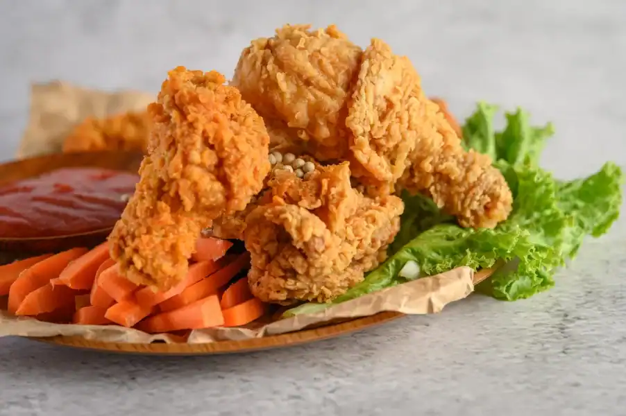 Crispy homemade fried chicken served with sliced carrots, lettuce, and dipping sauce