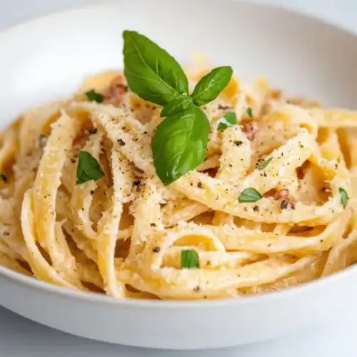 Bowl of creamy ricotta pasta topped with black pepper and fresh basil, perfect for a quick and easy dinner idea.