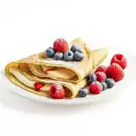 Folded homemade crepes with cream and fresh berries on a white plate