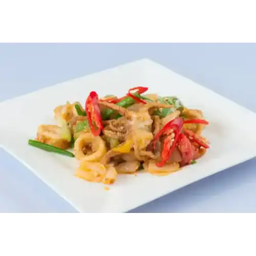Plate of crispy stir-fried squid with vegetables and red chili slices on a white square dish.