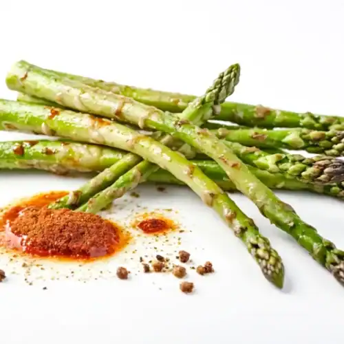 Roasted asparagus spears drizzled with dressing and served with Mediterranean spices.