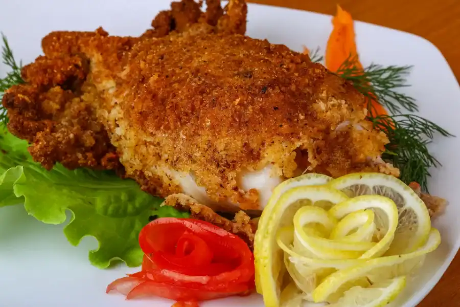 Golden stuffed calamari with crispy breadcrumb coating served with lemon slices and fresh vegetables