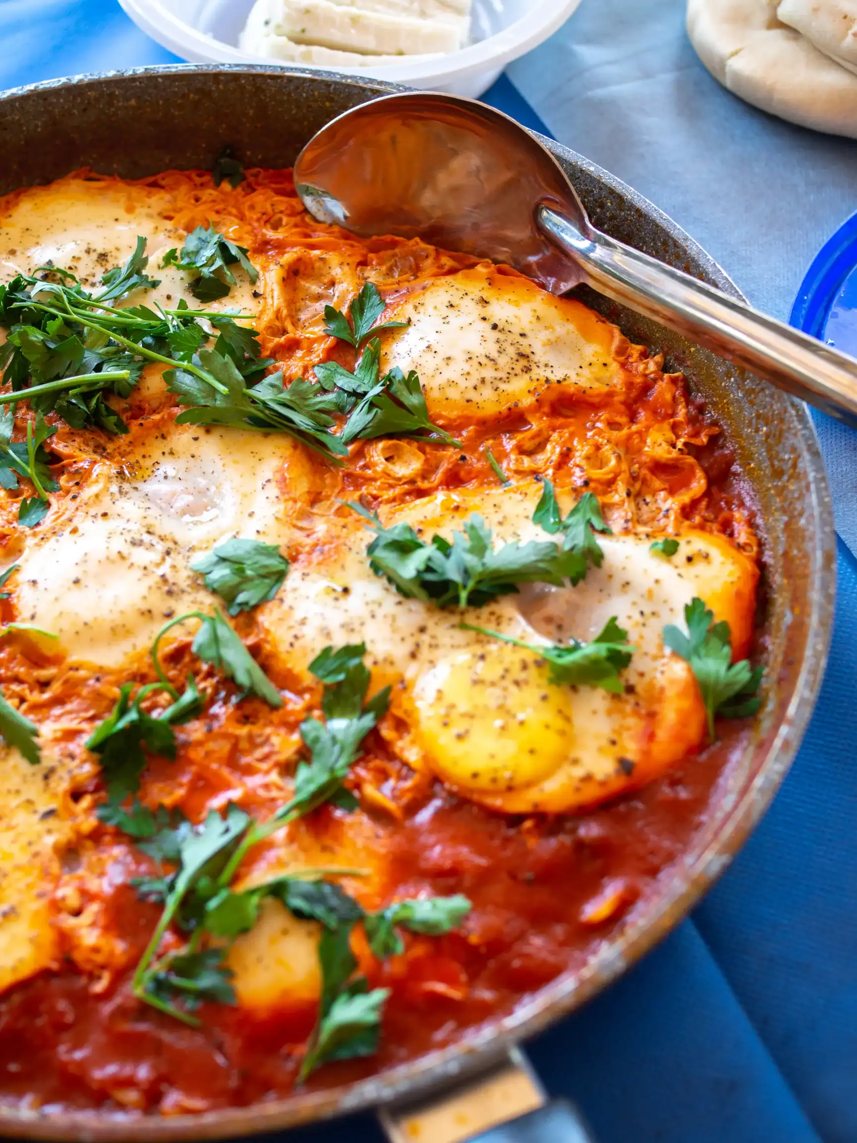 Indian Masala Shakshuka with poached eggs in spiced tomato sauce, topped with fresh cilantro