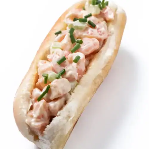 Classic East Coast lobster roll with creamy lobster filling and chopped chives on a split-top bun.