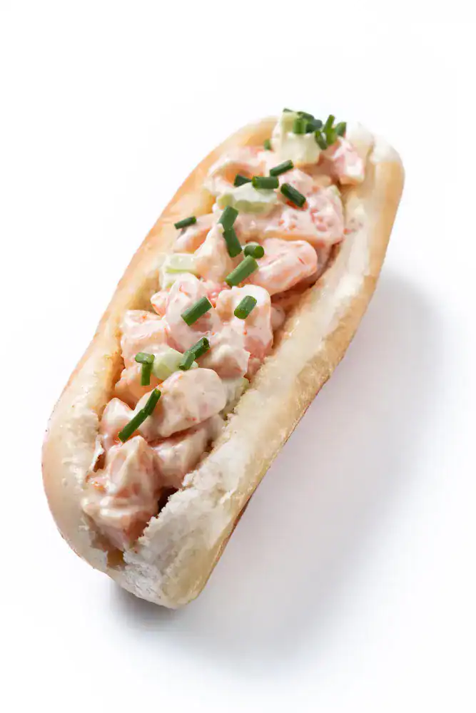 Classic East Coast lobster roll with creamy lobster filling and chopped chives on a split-top bun.