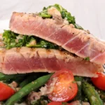 Seared tuna steaks served on sautéed greens with cherry tomatoes