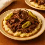 Mississippi pot roast served over mashed potatoes with pepperoncini peppers