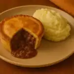 Savoury mince pie with mashed potatoes on a beige plate