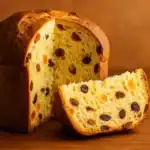 Freshly baked panettone sliced open on a wooden surface with warm tones