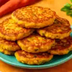 Stack of golden corn cakes on a turquoise plate with warm background tones