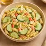 Creamy cucumber pasta salad with rotini, cucumber slices, cherry tomatoes, and dill served in a ceramic bowl.
